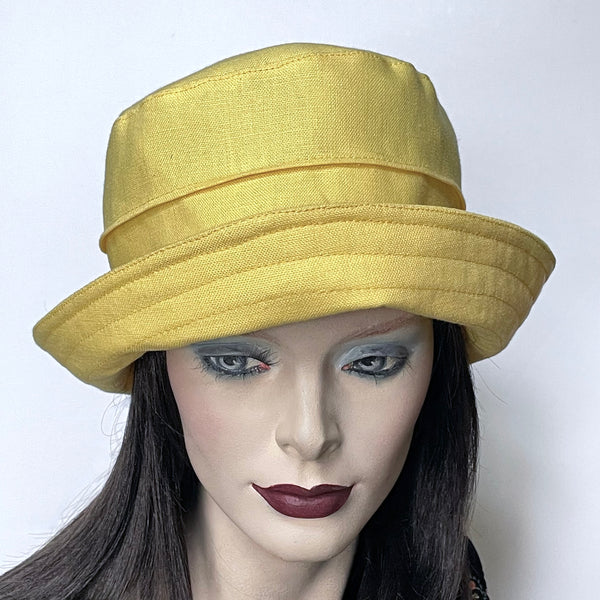 Find this one-of-a-kind, handmade “Jojo” hat by Ottawa artisan Sue Scott at Eclection Ottawa.  It's a practical and elegant shape that provides sun protection with style. The fabric is a mid-weight 100% linen in a lemon-yellow shade that brings a happy pop of colour in the warmer season. The shape is a straight-sided crown with a flat top and is finished off with the top-stitched Stella brim, a flexible brim that can be styled easily. Fully lined with satin. Size-medium: approximately 22 1/2’’