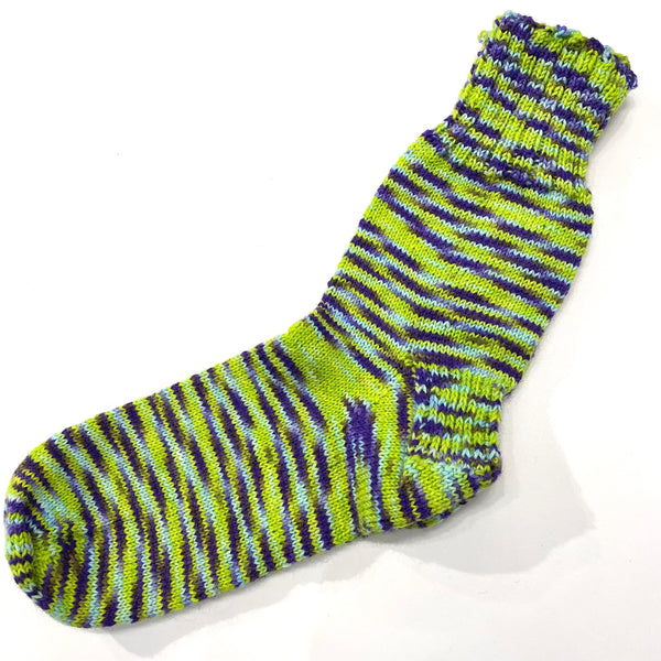 Hand-knit one-of-a-kind socks by Stella Bedard, aka the British Hat Lady. Labours of love and knit with fine stitches in the best wool blends. No one makes them like this anymore. The pair of lime variegated with purple tone socks are knit with 75% wool and 25% nylon for durability. Length is 10’’, which is equivalent to a men’s size 8 shoe and a women’s size 10.