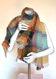 Wrap yourself in this soft and cozy blanket scarf this winter. Its generous size of 24X71 inches and its multicoloured plaid in tones of buttery yellow, orange, soft aqua, chambray and black allow for versatile wear.  Woven in soft, medium-weight polyester fibre with a wearable no-itch texture, it has a nice drape and natural feel and a charming boucle texture that gives it a vintage handwoven look. It is finished off with rustic-looking frayed edges on all sides. Hand-washable, hang to dry. Draped