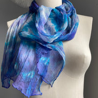 It has been created with Shibori dyeing technique on 100% pure silk crinkle chiffon and is totally unique. A piece of art to wear!  The silk chiffon is Summer weight (5 mm) and light and diaphanous with a crinkle texture that gives it body, interest, and charm. The finely finished hand-rolled piece measures flat at 22” X 72” but looks narrower with its crinkles. Mix of vibrant blue, purple and a bit of white