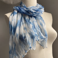 It has been created with Shibori dyeing technique on 100% pure silk crinkle chiffon and is totally unique. A piece of art to wear!  The silk chiffon is Summer weight (5 mm) and light and diaphanous with a crinkle texture that gives it body, interest, and charm. The finely finished hand-rolled piece measures flat at 22” X 72” but looks narrower with its crinkles. Denim blue on white background 