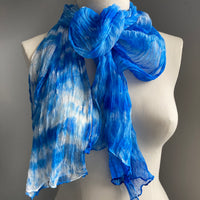 It has been created with Shibori dyeing technique on 100% pure silk crinkle chiffon and is totally unique. A piece of art to wear!  The silk chiffon is Summer weight (5 mm) and light and diaphanous with a crinkle texture that gives it body, interest, and charm. The finely finished hand-rolled piece measures flat at 22” X 72” but looks narrower with its crinkles.  Mix of vibrant  Mediterranean sky blue and white