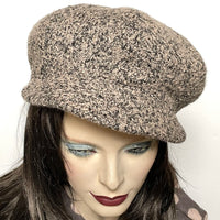 This one-of-a-kind hat, handmade by local artisan Sue Scott, is called the "Casquette". It is fashioned in a soft boucle texture wool blend fabric in an easy-to-wear granite colour in a mix of taupe, charcoal and black. The shape is an eight-part crown, with some volume and a front peak. It is finished off with a covered button in the same fabric on top. Fully lined with windproof Kasha lining. Size medium: Approximately 22 1/2’’ with an elastic in the back so it can go a little larger.  