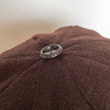 Details of the brown bakelite button trim on top of the casquette.