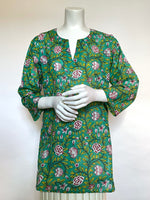 This delightful Summer tunic is 100% lightweight, block-printed Indian cotton. It's a terrific,classic and versatile cut which is wearable with leggings, capris, shorts, skirts, you name it! It has a flattering shoulder fit from which it flares slightly into a body-skimming silhouette with side seams open over the hips. It's washable in cold water, and hang dries quickly. This print is a vibrant floral vine print in raspberry red with touches leafy green on a conservatory green background.