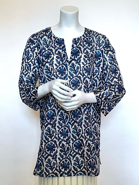 This delightful Summer tunic is 100% lightweight, block-printed Indian cotton. It's a terrific, classic cut, wearable with leggings etc... and it has a flattering shoulder fit from which it flares slightly into a body-skimming silhouette with side seams open over the hips. It's washable in cold water, and hang dries quickly. The print of overlapping finials is in shades of blue like indigo and ink on a creamy background.