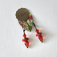 Find these one-of-a-kind, handmade dangle earrings by local artisan Khalia Scott at Eclection Ottawa. These earrings are carefully crafted out of faceted cranberry red crystal and glass beads with sliced tinted coral beads and finished off with oxidized bronze metal findings and hooks. They are approximately 1 1/2" in length and lightweight at 4g/pair.