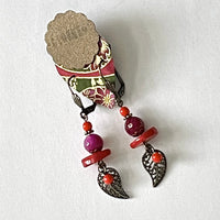 These earrings are carefully crafted out of faceted tinted agate in a blend of red and magenta with sliced tinted coral beads, tiny coral-red glass beads and oxidized bronze leaf findings. They are finished off with oxidized bronze findings and hooks. They are approximately 2" in length and lightweight at 6g/pair.