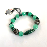 Find these handmade bracelets by local artisan Khalia Scott at Eclection Ottawa. They are crafted out of a mix of rare, polished and hardened semi-precious malachite chips and oblong beads, faceted tinted agate, small zinc alloy beads and findings.  It is strung by hand on a heavy and durable elastic cord for comfy wear and ease of fit. Size medium. 