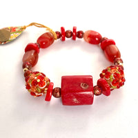 This one-of-a-kind bracelet is handmade by Ottawa artisan Khalia Scott. The gemstone theme is named "Power " and it is part of a collection created to foster and nurture the feeling of power and control over our lives in the year to come. It is carefully crafted out of tinted coral, large and beautifully textured lampwork beads, small glitter glass beads in a rich tone of red and tinted agate. It is carefully strung by hand on a heavy and durable elastic cord. Size medium. 