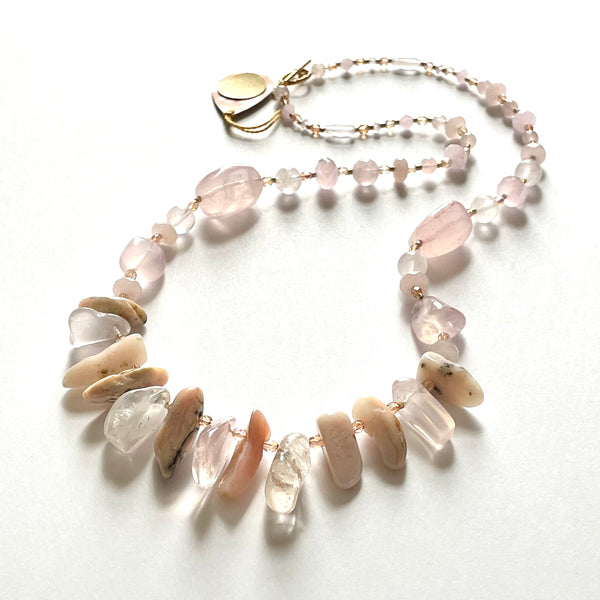 Find this handmade necklace by local artisan Khalia Scott at Eclection Ottawa. This necklace has large and smaller natural and polished rose quartz, tinted agates, and shell, mixed with different shapes of faceted Czech crystals and glass seed beads. It is strung securely by hand on a heavy coated multi-strand tiger tail cord and is finished off with a beautiful gold plated toggle clasp and findings. It is opera length measuring approximately 28 3/4" in length. 