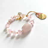Find this handmade bracelet by local artisan Khalia Scott at Eclection Ottawa. It is carefully crafted out of rose quartz, faceted crystals and agates, presented with natural and polished chunky rose quartz at its centre and finished off with a gold plated leaf charm. It is carefully strung by hand on a heavy and durable elastic cord for comfy wear and ease of fit. Available in two sizes. The  Medium/Large is approximately 7" in length. 