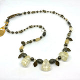 This one-of-a-kind necklace is handmade by Ottawa artisan Khalia Scott.  This necklace has large and smaller natural, polished semi-precious citrine beads, a mix of polished and raw pyrite stones, Czech faceted crystals and oxidized brass leaves. It is strung securely by hand on a heavy coated multi-strand tiger tail cord and is finished off with a beautiful oxidized brass flower clasp and findings. It measures approximately 27 1/2" in length.  