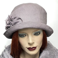 Find this handmade “Cloche” hat by local artisan Sue Scott at Eclection Ottawa. It hat is fashioned in 100% lighter-weight linen in an easy-to-wear dusty lilac shade that brings colour to your spring and summer outfits. The shape is a classic rounded cloche crown that features a flexible brim that can style to your tastes. This hat is finished off with a voluminous hand-sewn rose trim in the same fabric and is fully lined with satin.  Size-medium: approximately 22 ½.’’ 