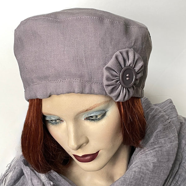 Find this handmade “Rideau” beret by Ottawa artisan Sue Scott at Eclection Ottawa. It is fashioned in 100% lighter-weight linen in an easy-to-wear dusty lilac shade that brings colour to your spring and summer outfit. This hat is enlivened by a hand-sewn cockade ribbon rosette trim in the same fabric with a vintage button at its center as a finishing touch. It presents an adjustable interior ribbon for adjustability. Fully lined with satin. Size-medium: ranging from 21 ½’’- 22 ¾.’’