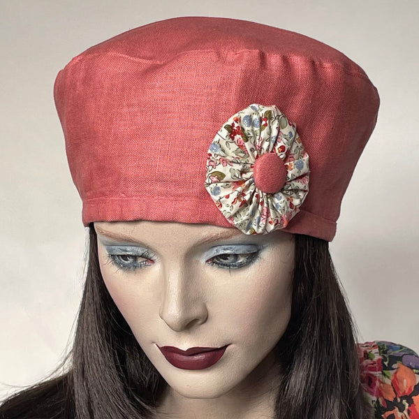 Find this handmade “Rideau” beret by Ottawa artisan Sue Scott at Eclection Ottawa. It is fashioned in 100% mid-weight linen in a soft cameo pink shade that brings a pop of colour in the warmer season.  It is enlivened by a hand-sewn rosette in matching cotton floral fabric and a cameo pink covered button as a finishing touch. It presents an adjustable interior ribbon for adjustability and can be worn in a variety of ways. Fully lined. Size-medium: ranging from 21 ½’’ to 22 ¾.’’