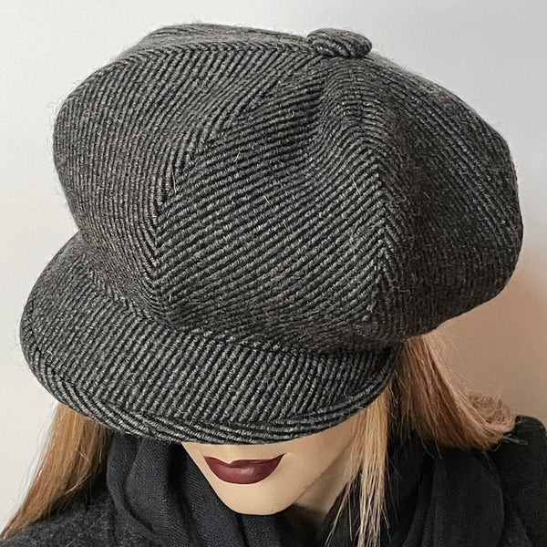 Find this one-of-a-kind Casquette, handmade by local artisan Sue Scott at Eclection Ottawa. It is fashioned in a beautiful striped cashmere and wool blend fabric in grey and black colours that add texture and visual interest to this classic neutral hat. The shape is an eight-part crown, with some volume and a front peak. Covered button in the same fabric on top. Fully lined with a thick windproof Kasha lining. Size medium-large: Approximately 22 1/2’’ with an elastic in the back.  