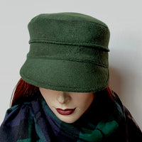Find this one-of-a-kind Crumper hat, handmade by local artisan Sue Scott, at Eclection Ottawa. It is fashioned in a rich dark conifer green cashmere and wool blend fabric that will bring softness and colour to your outfit this winter. The shape is a straight-sided, flat-topped crown, with a classic front peak that conveniently keeps snow off of your eyelashes. It is fully lined with a satiny, flannel-backed Kasha lining that’s easy on the hair and stops the wind. Size-medium: Approx 22 1/2" 