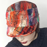 Find this handmade "Crumper" hat by local artisan Sue Scott at Eclection Ottawa.  It is fashioned in luxurious poly/cotton blend panne velvet fabric featuring a fun brushstrokes print in shades of reds, pinks, blues and greens which is perfect to add colour in the colder months. The shape is a straight-sided, flat-topped crown, with a classic front peak, and is lined with a thick wind-resistant lining. Size-medium,  22 1/4"