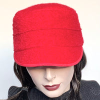 This one-of-a-kind hat, handmade by local artisan Sue Scott, is called the "Crumper".  It is fashioned in red boiled wool with a rich bouclé texture which is perfect for adding a bit of colour in the colder months. The shape is a straight-sided, flat-topped crown, with a classic front peak. Fully lined with a satiny, flannel-backed Kasha lining that’s easy on the hair and protects from the wind for even more warmth. Size-medium,  22 1/4"