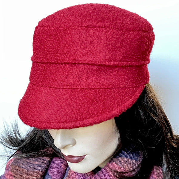 Find this one-of-a-kind Crumper hat, handmade by local artisan Sue Scott, at Eclection Ottawa. It is fashioned in a fun deep red wool blend fabric with a rich and cozy boucle texture which is perfect for adding a bit of colour in wintertime. The shape is a straight-sided, flat-topped crown, with a classic front peak. It is finished off with a satiny, flannel-backed Kasha lining that’s easy on the hair and stops wind for added warmth. Size-medium: Approximately 22 1/2" 