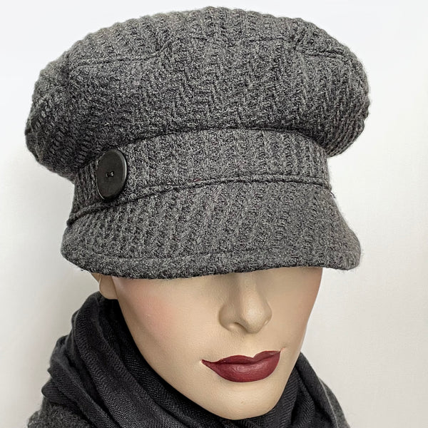 This Captain cap by artisan Sue Scott is fashioned in a charcoal wool blend fabric with a rich waffle texture which adds a touch of coziness to this classic hat. The shape is a classic two-part crown with some volume and a nice smart peak in the front that protects you from snowflakes. It is finished off with a vintage button on the side and is fully lined with a satiny, flannel-backed Kasha lining that’s easy on the hair and stops wind for added warmth. Size small: Approximately 22’’ 
