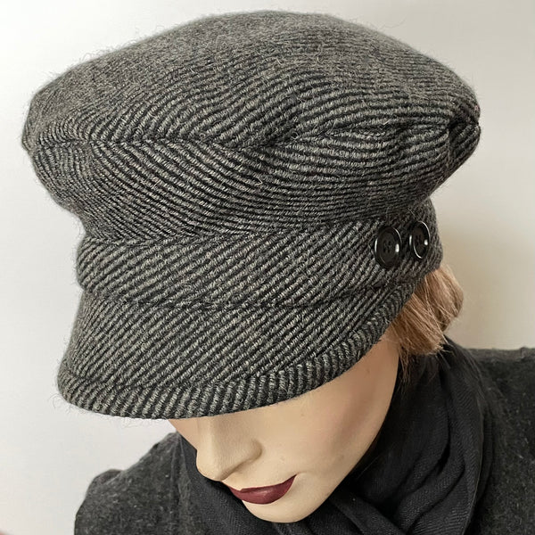 Find this One-of-a-kind, handmade “Captain” hat by local artisan Sue Scott at Eclection Ottawa. It is fashioned in a beautiful grey and black striped wool and cashmere blend fabric that adds texture and visual interest to this classic neutral hat. The shape is a classic two-part crown with some volume and a nice smart peak in the front. It is finished off with vintage buttons accent and is lined with a thick, tightly woven wind-stopping lining for added warmth. Size-small: Approximately 22’’  