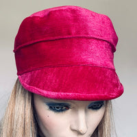 This one of a kind hat, handmade by local artisan Sue Scott, is called the "Crumper". It is fashioned out of a vibrant hot pink cotton/polyester blend velveteen fabric for a delicious pop of colour in the colder months. The shape is a straight-sided, flat topped crown, with a front peak. Fully lined. Size-medium 22 1/4"