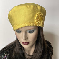 Find this handmade “Rideau” beret by Ottawa artisan Sue Scott at Eclection Ottawa. It is fashioned in mid-weight 100% linen in a lemon-yellow shade that brings a happy pop of colour in the warmer season. This hat is finished off with a hand-sewn vintage cockade ribbon trim in the same fabric adorned by a matching vintage button at its center. It has an adjustable interior ribbon, and it can be worn in a variety of ways. Fully lined with satin. Size-medium: ranging from 21 ½’’- 22 ¾.’’