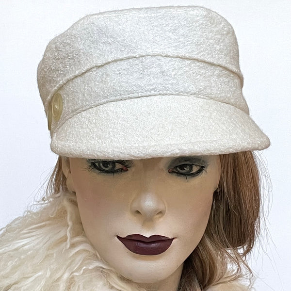 Find this one-of-a-kind Crumper hat, handmade by local artisan Sue Scott, at Eclection Ottawa. It is fashioned in a classic winter white wool blend with a cozy texture in an easy-to-wear off-white colour. The shape is a straight-sided, flat-topped crown, with a classic front peak. It is finished off with vintage buttons on the sides and is fully lined with a thick windproof lining that’s easy on the hair and stops the wind. Size-medium: Approximately 22 1/2" Dry clean only.