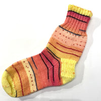 Hand-knit one-of-a-kind socks by Stella Bedard, aka the British Hat Lady. Labours of love and knit with fine stitches in the best wool blends. No one makes them like this anymore. This charming pair of sunrise multicoloured socks are knit with 75% wool and 25% nylon for durability. Length is 10’’, which is equivalent to a men’s size 8 shoe and a women’s size 10.