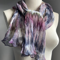 This one-of-a-kind silk scarf has been handmade in Ottawa at Shiborica's studio. It has been created with Shibori dyeing technique on 100% pure silk crinkle chiffon and is totally unique. A piece of art to wear!  The silk chiffon is Summer weight (5 mm) and light and diaphanous with a crinkle texture that gives it body, interest, and charm.  hand-rolled  finish. 22” X 72” .Mix of Ink, dusty rose greens and white and a touch of orchid. More muted tones