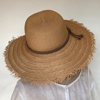 Find this versatile toast1tan hat at Eclection Ottawa. The “Myrtle” is made out of paper braid in an open weave design with a matte texture. It has a rounded oval crown and a large wireless brim with fringed edge. Delicate braided round trims in a ultrasuede. With adjustable elastic. Size  22 3/8" to smaller. Brim 4 3/4". Crown 4 1/2".