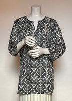 This delightful Summer tunic is 100% lightweight, block-printed Indian cotton. It's a terrific, classic and versatile cut which is wearable with leggings, capris, shorts, skirts, you name it! It has a flattering shoulder fit from which it flares slightly into a body skimming silhouette with side seams open over the hips. It's washable in cold water, and hang dries quickly. This print is a fun abstract in black and gunmetal grey on a white background.