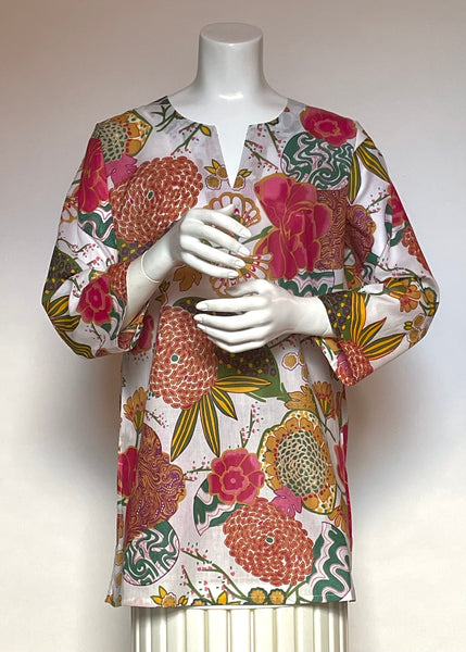 This delightful Summer tunic is 100% lightweight, block-printed Indian cotton. It's a terrific, classic and versatile cut which is wearable with leggings, capris, shorts, skirts, you name it! It has a flattering shoulder fit from which it flares slightly into a body-skimming silhouette with side seams open over the hips. It's washable in cold water, and hang dries quickly. This print is a fanciful tropical garden in rainbow colours on a white background.