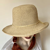 Find this flattering and versatile hat at Eclection Ottawa. the “Ziggy” has a large wired brim we love for sun protection with style. It's made out of natural crocheted paper and has a simple twisted paper trim knotted in a bow. The shape is a flexible rounded crown and a soft angled wired brim. Adjustable inside, 22 1/2" to smaller. Brim 3 1/4"-3 1/2" / Crown roughly 4 1/2"