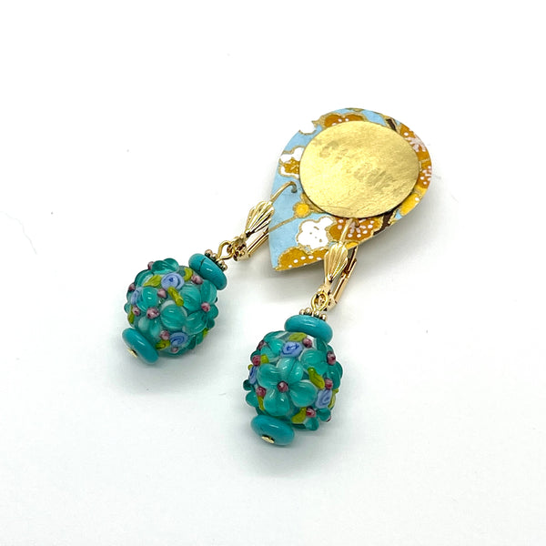 The gemstone theme is named "Patience” and it is part of a collection created to nurture and foster the feeling of patience and calm in our life. These earrings are carefully crafted out of tinted howlite in a gorgeous shade of turquoise, large and beautifully textured lampwork glass beads and are finished off with gold-plated findings and lever-backed hooks. They measure approximately 1 3/4" in length and weigh 12g/pair.
