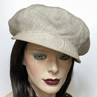 This hat, handmade by local artisan Sue Scott, is called the "Casquette". This hat is made of 100% mid-weight linen in a soft neutral sand shade that will become your go to summer hat for years to come. The shape is a classic eight-part voluminous crown, with a smart front peak that protects from the sun. It is finished off with a metal button trim on top and is fully lined with satin. Size medium/large at approximately 22 1/2’’ with an elastic in the back that gives it some give.