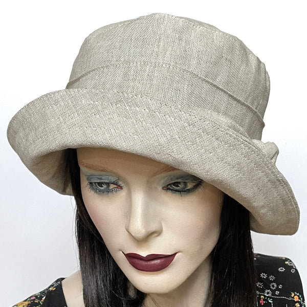 Find this one-of-a-kind, handmade “Jojo” hat by Ottawa artisan Sue Scott at Eclection Ottawa. The fabric is a mid-weight 100% linen in a soft neutral sand shade that will become your go to hat in the warmer season. The shape is a straight-sided crown with a flat top and is finished off with the top-stitched Stella brim, a flexible brim that can be styled easily. Fully lined with satin. Size-medium: approximately 22 1/2’’
