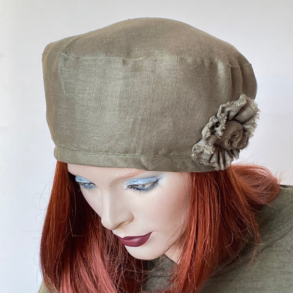 One-of-a-kind, handmade “Rideau” beret by Ottawa artisan Sue Scott. It is fashioned in 100% lightweight linen in a versatile and easy-to-wear sage green colour. It has an elegance that can stretch from easy daywear to a special occasion. It is finished off with a hand-sewn rosette in the same fabric. It has an adjustable interior ribbon, and it can be worn in a variety of ways. Fully lined with Bemberg lining. Size-medium: ranging from 21 ½’’- 22 ¾.’’